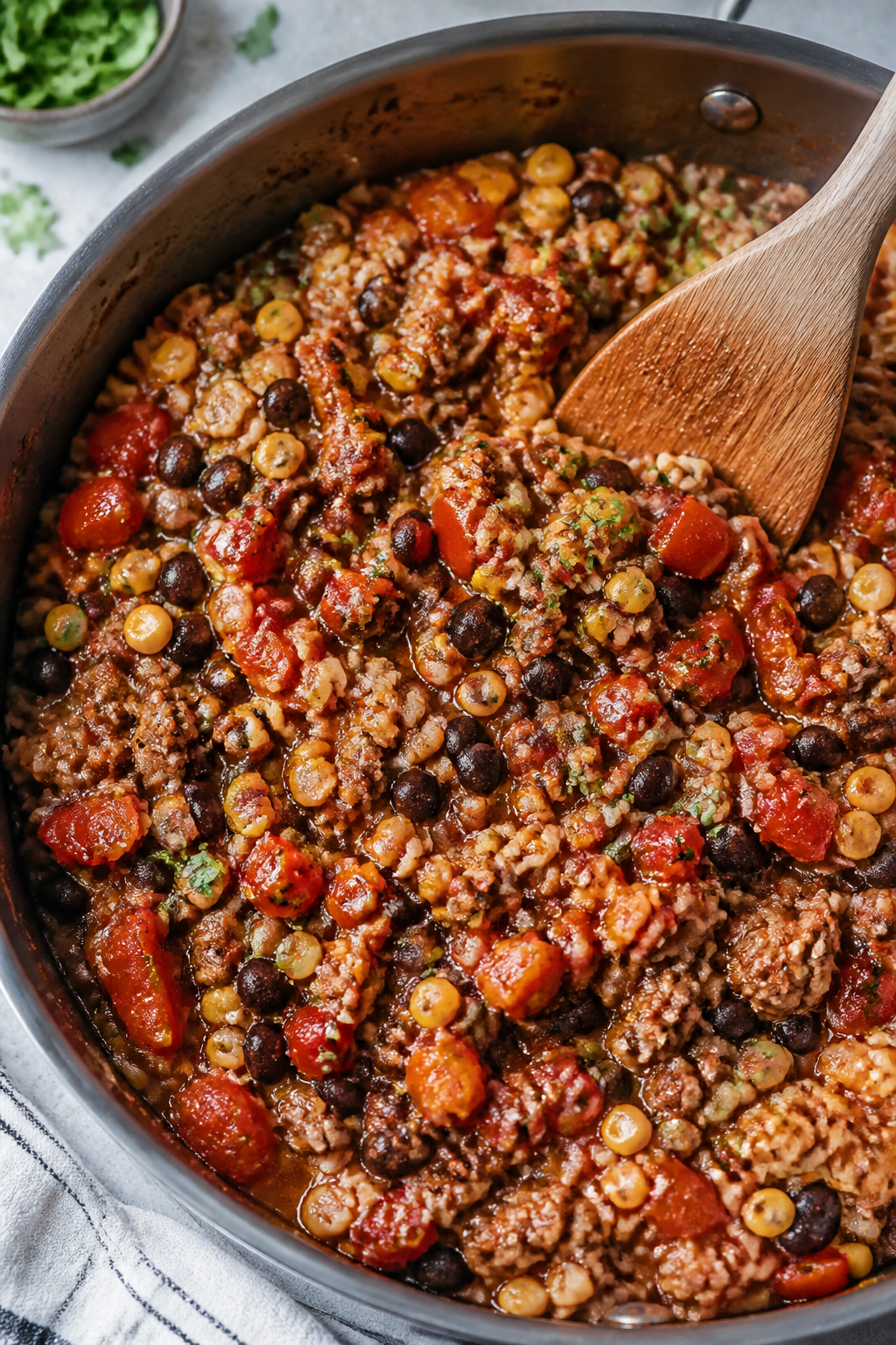 Cooking process: Seasoned lean ground beef mixture simmering in a large skillet, fully cooked and co