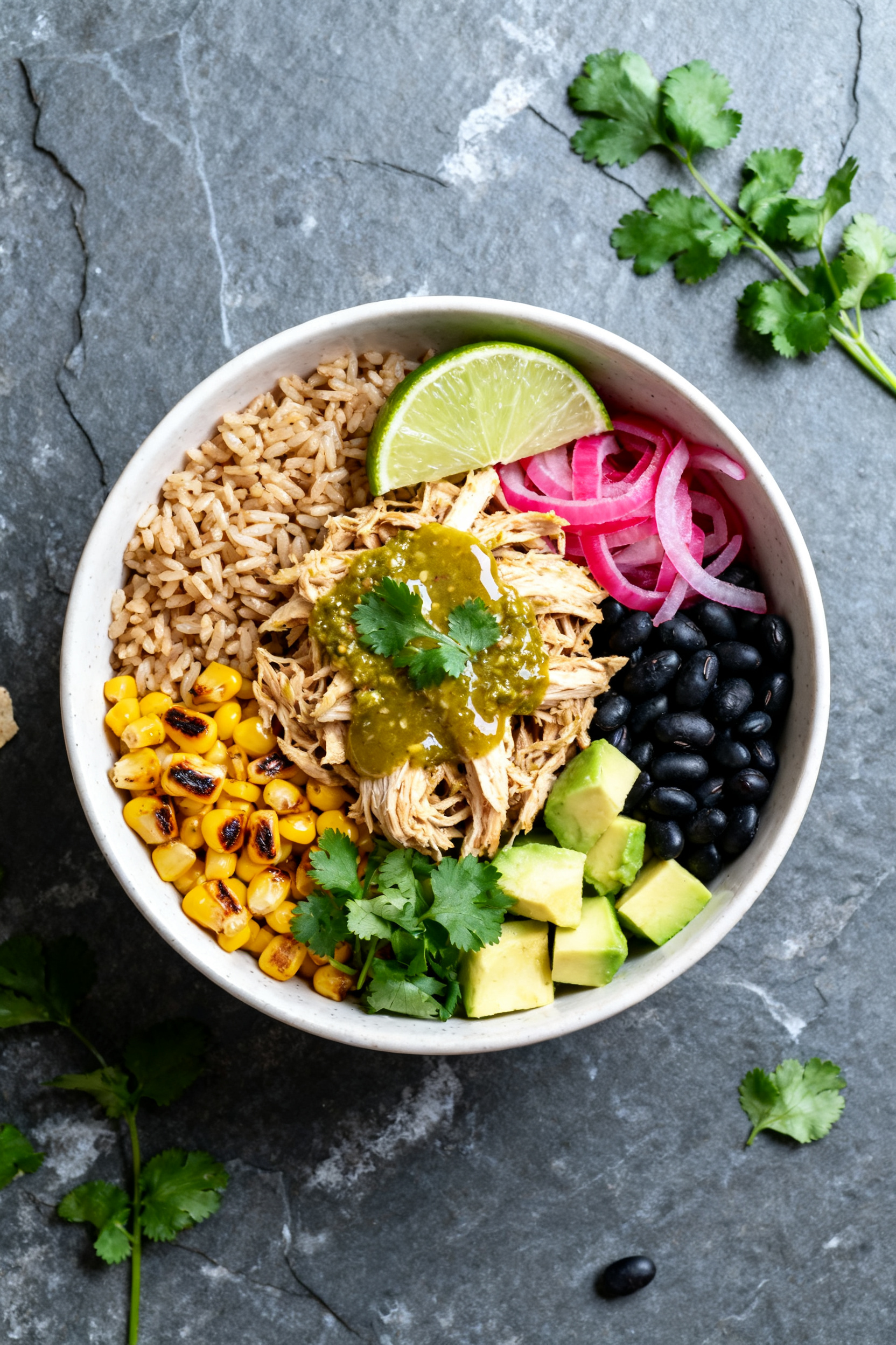 Overhead “tasty top view” bowl: High-protein burrito bowl featuring salsa verde shredded chicken