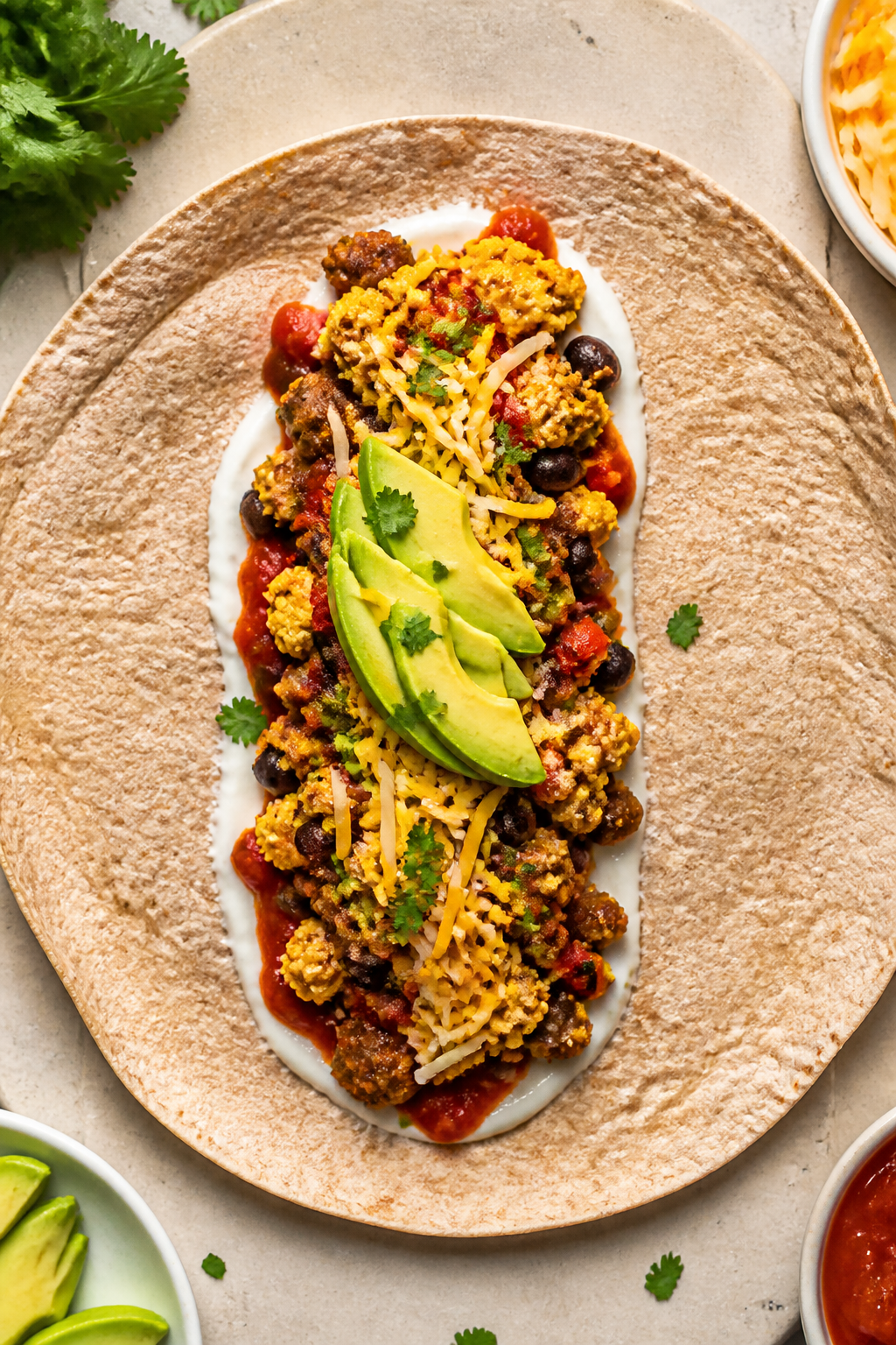 Tasty top view, assembly: Overhead shot of a warmed whole-wheat tortilla on a neutral board, mid-ass