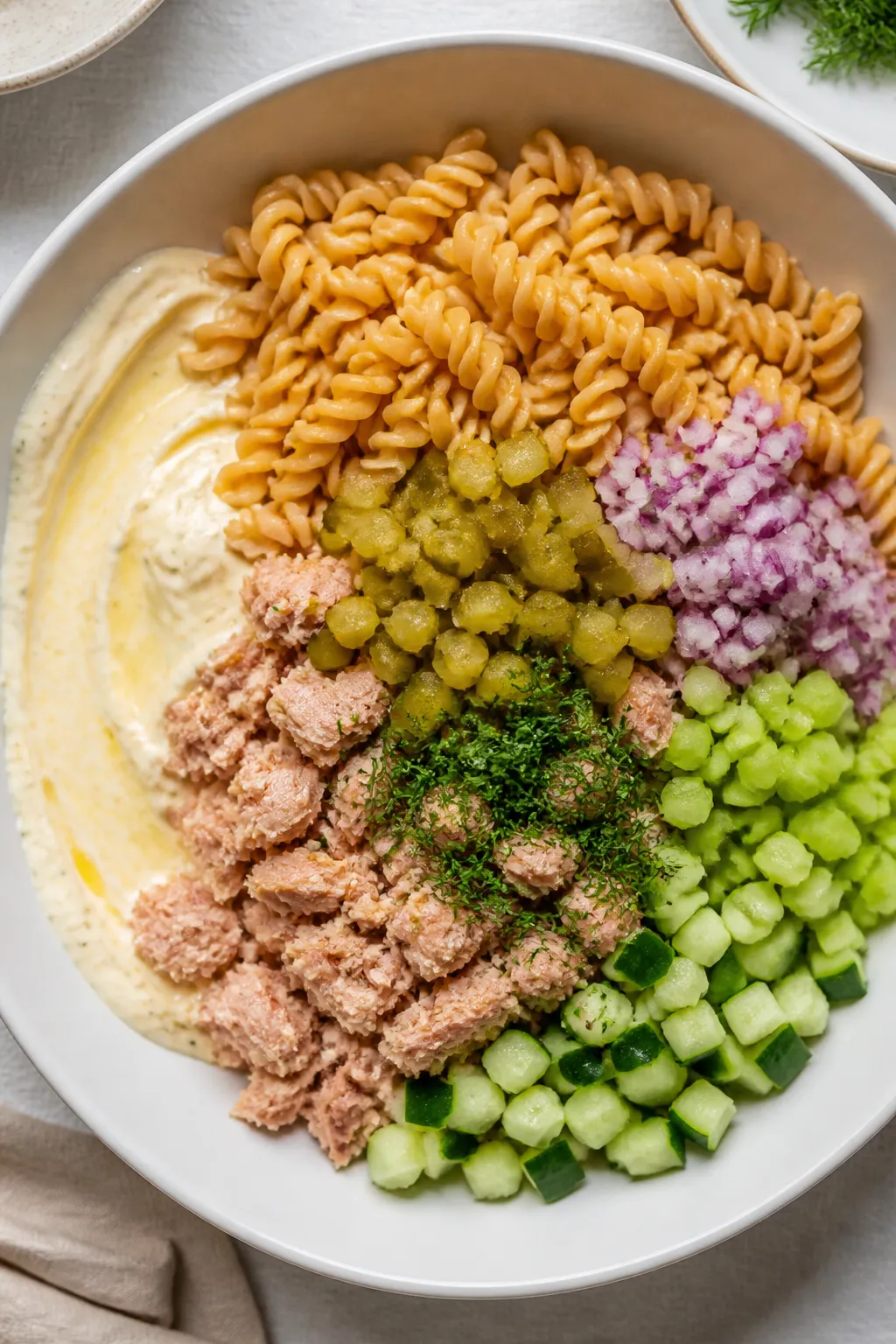 Cooking process, overhead: Al dente high‑protein chickpea pasta just cooled and being folded into