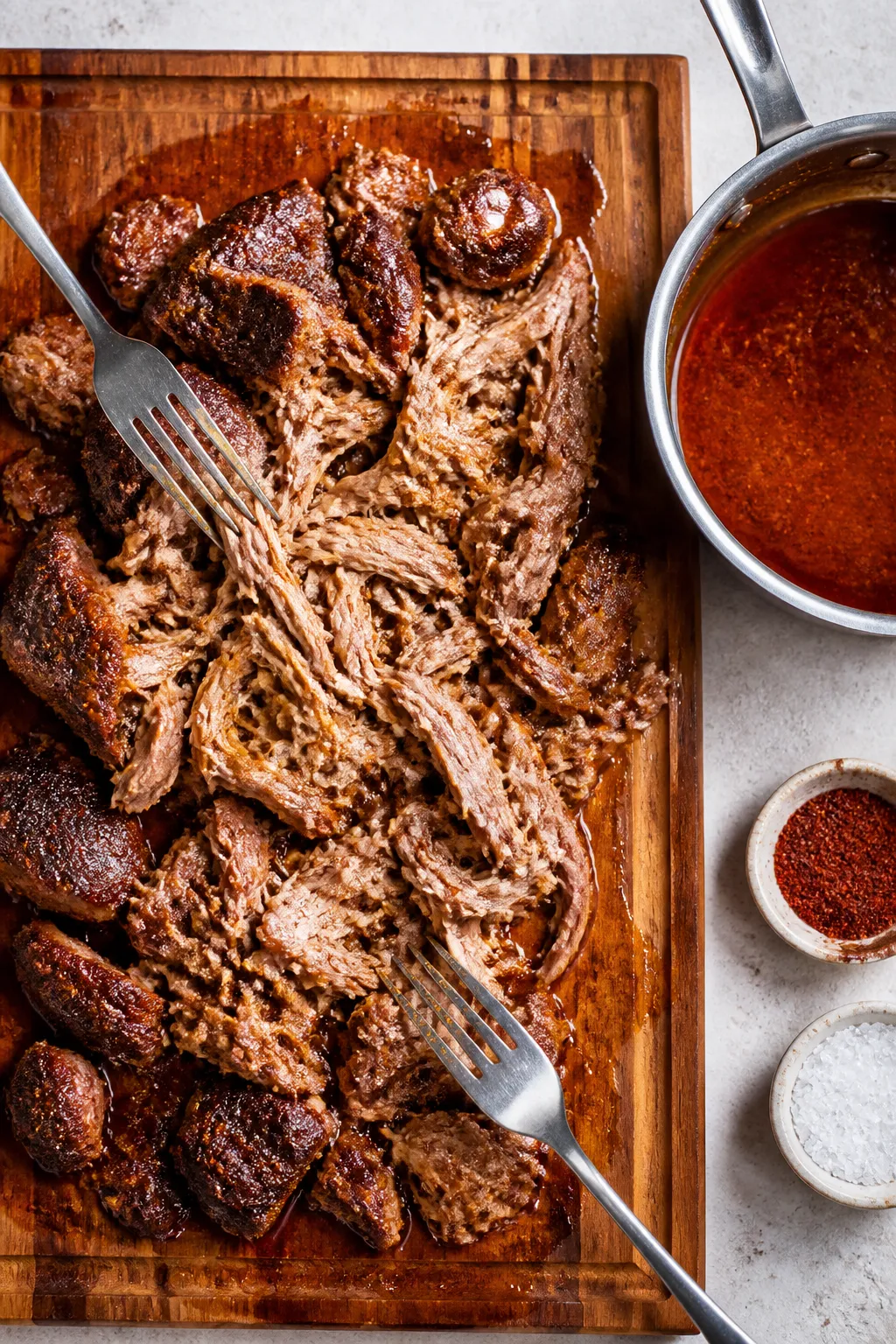 Cooking process: Overhead shot of tender cooked pork shoulder just after shredding on a wooden board