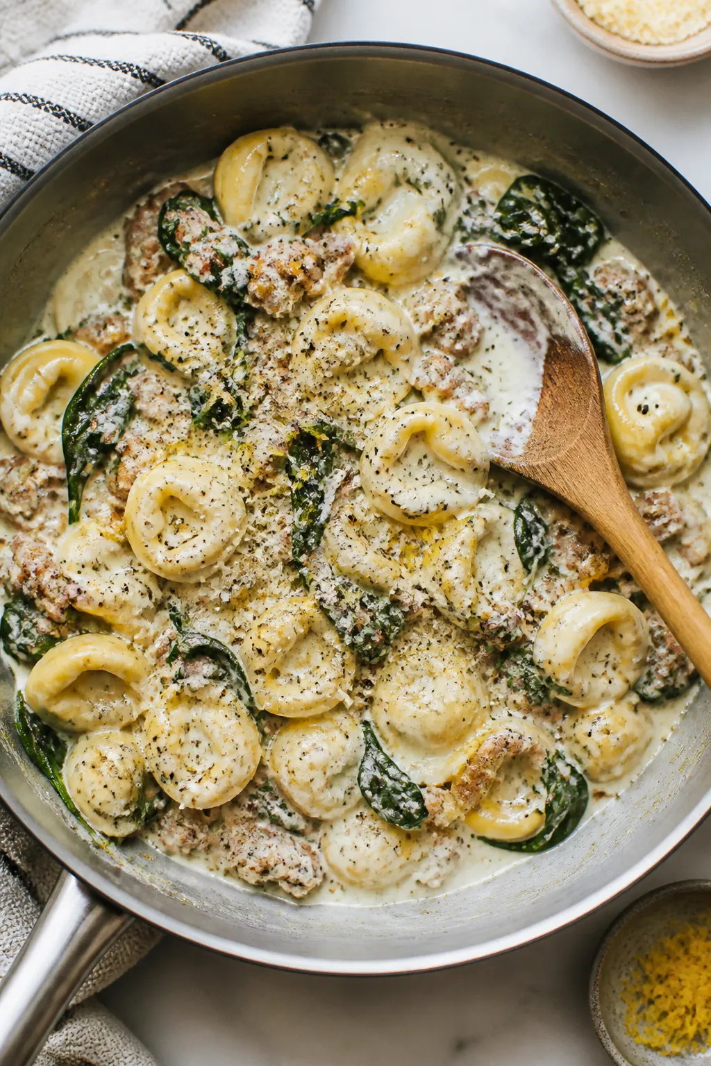 Tasty top view, one-pan scene: Overhead shot of cheese tortellini simmering in a silky cream-and-chi
