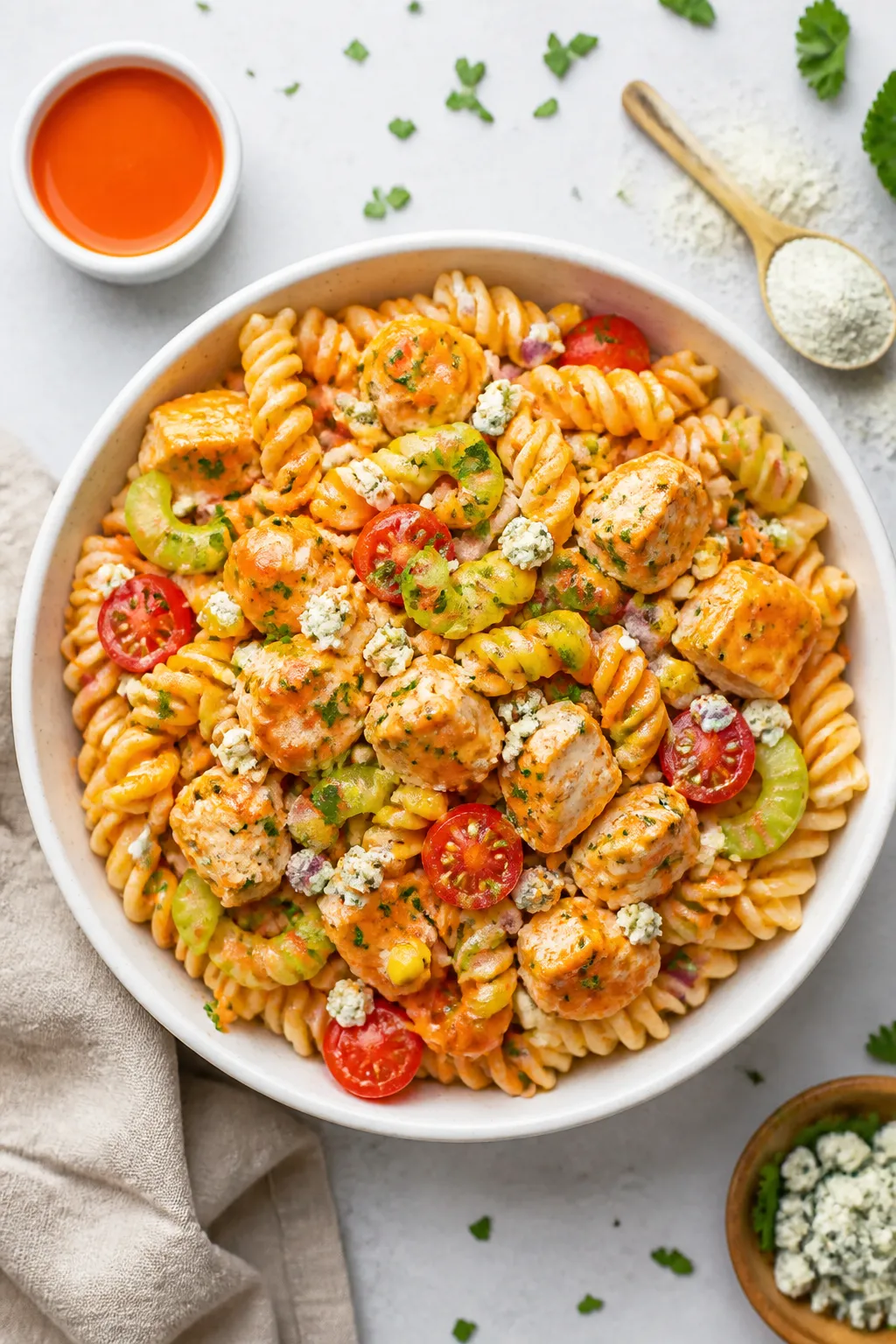 Tasty top view: Overhead shot of Buffalo Ranch Protein Pasta Salad in a wide, white ceramic bowl, ev