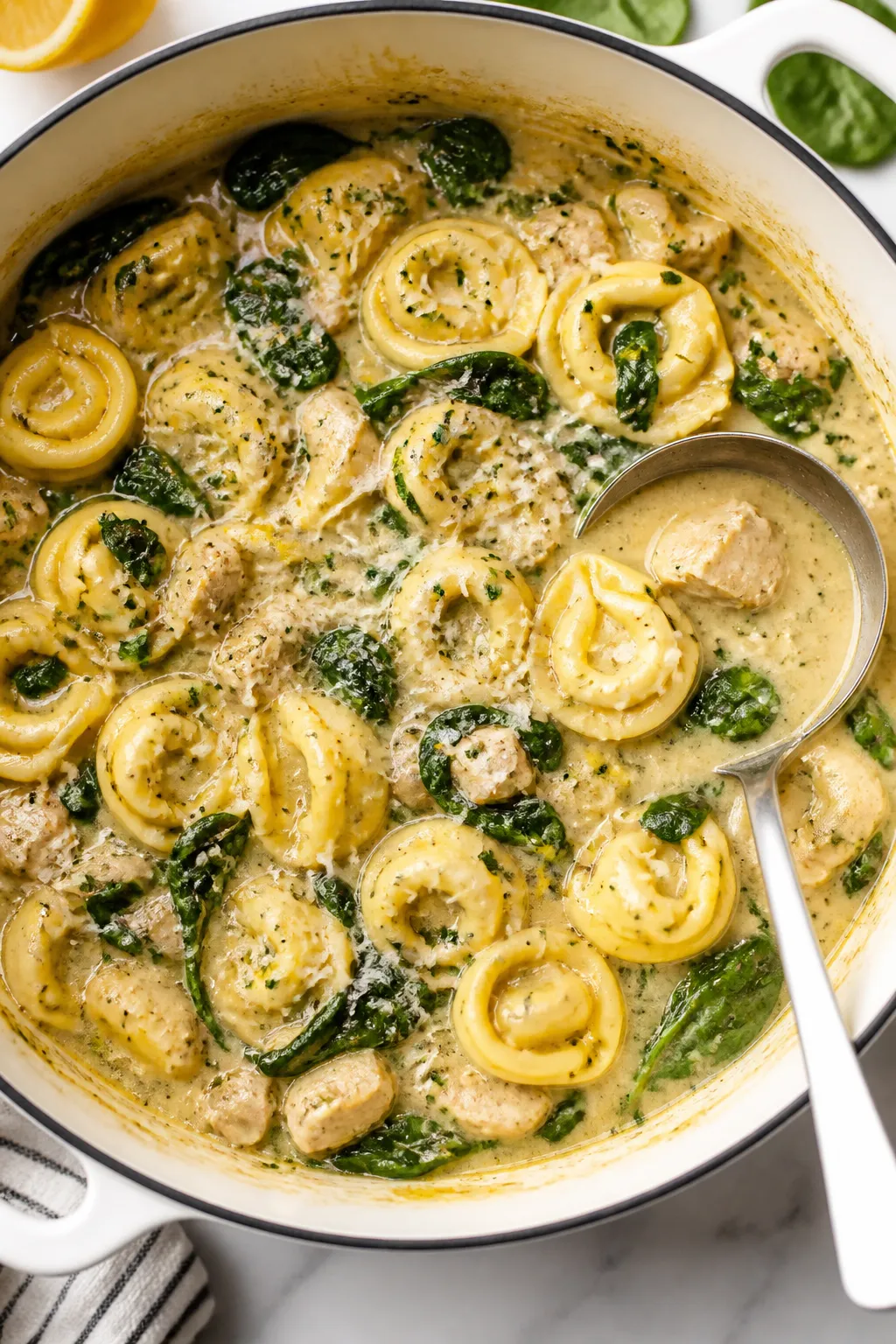 Tasty top view: Overhead shot of the one-pot chicken tortellini at peak finish in a Dutch oven—pil
