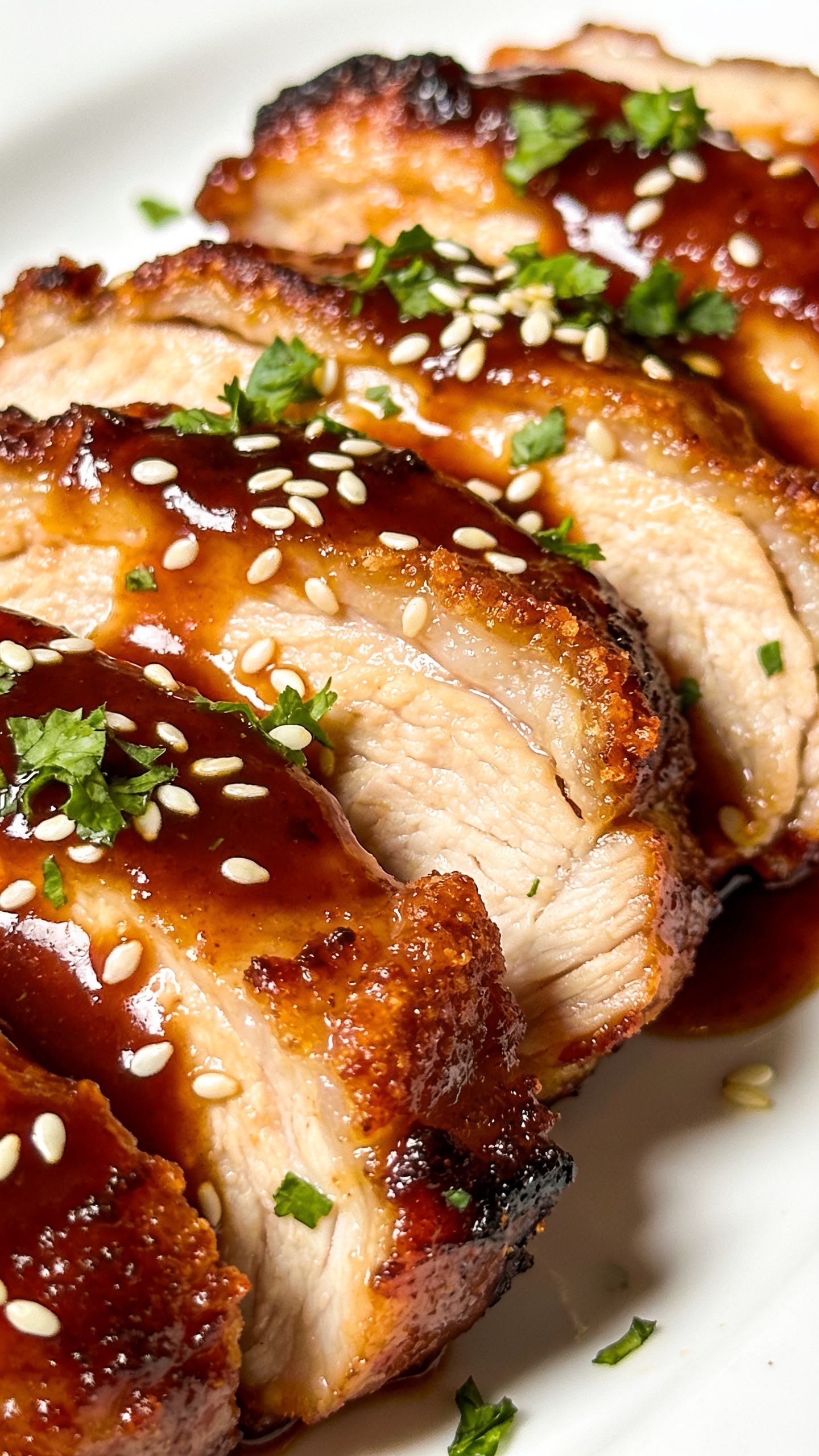 A ultra-close, studio-style macro of the finished dish from a different angle, focusing on juicy, tender interior and crispy edge with sauce coating and sesame/parsley flecks, fresh herbs lightly sprinkled, vivid colors, shallow depth of field, natural lighting, 90–95% frame filled with the plate to emphasize texture and richness.